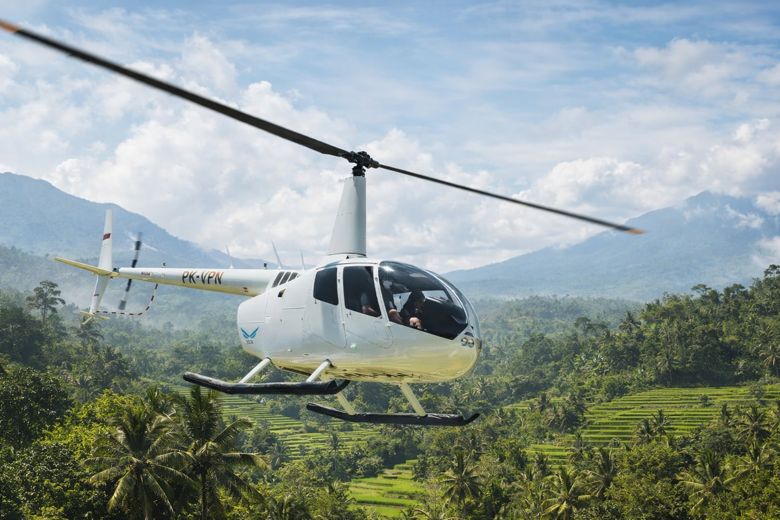 Вертолет Robinson R66 Turbine Marine на вертолетной площадке на Бали с видом на рисовые террасы